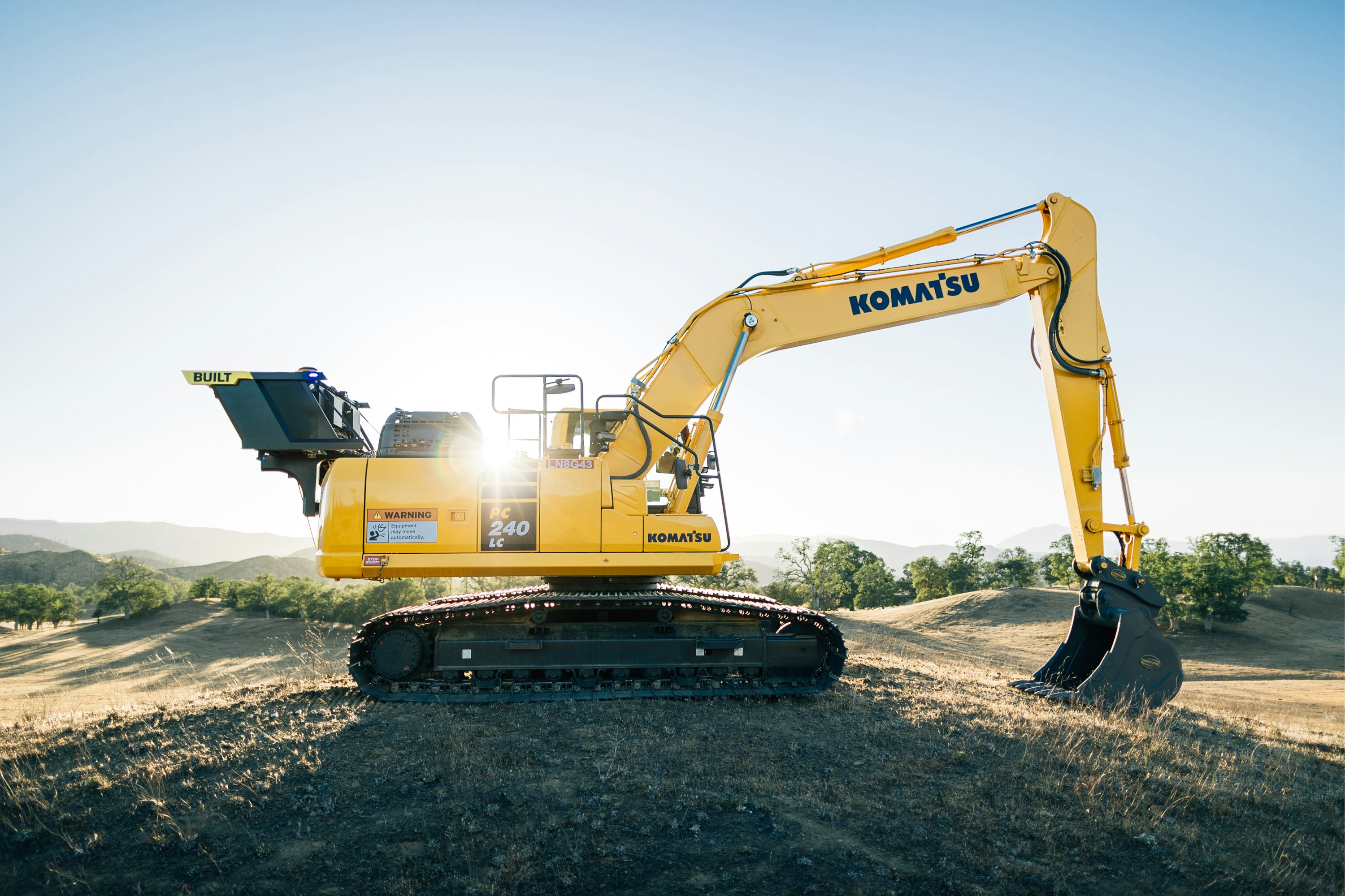 Professional groundworks excavator on construction site at sunset